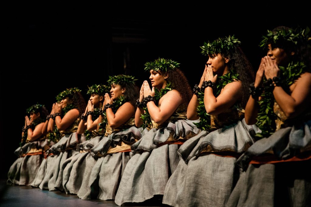 Hula halau's female dancers perform on stage