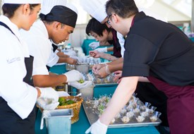 Culinary workers prepare single-serving individual dishes.